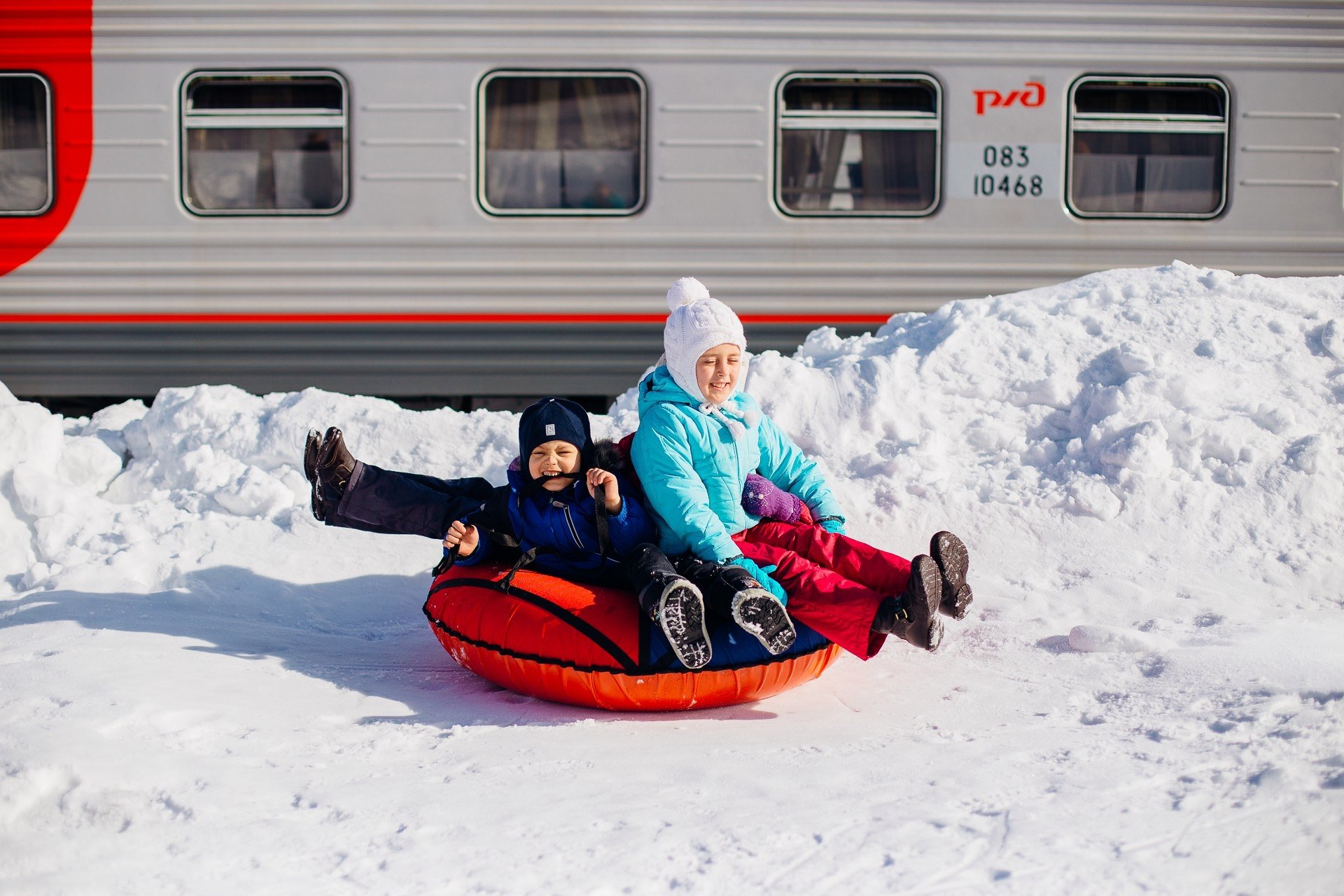 Ребенок едет на поезде с бабушкой. Туристический поезд. Путешествие на электричках зима. Поездка на поезде зимой. Железная дорога для детей.
